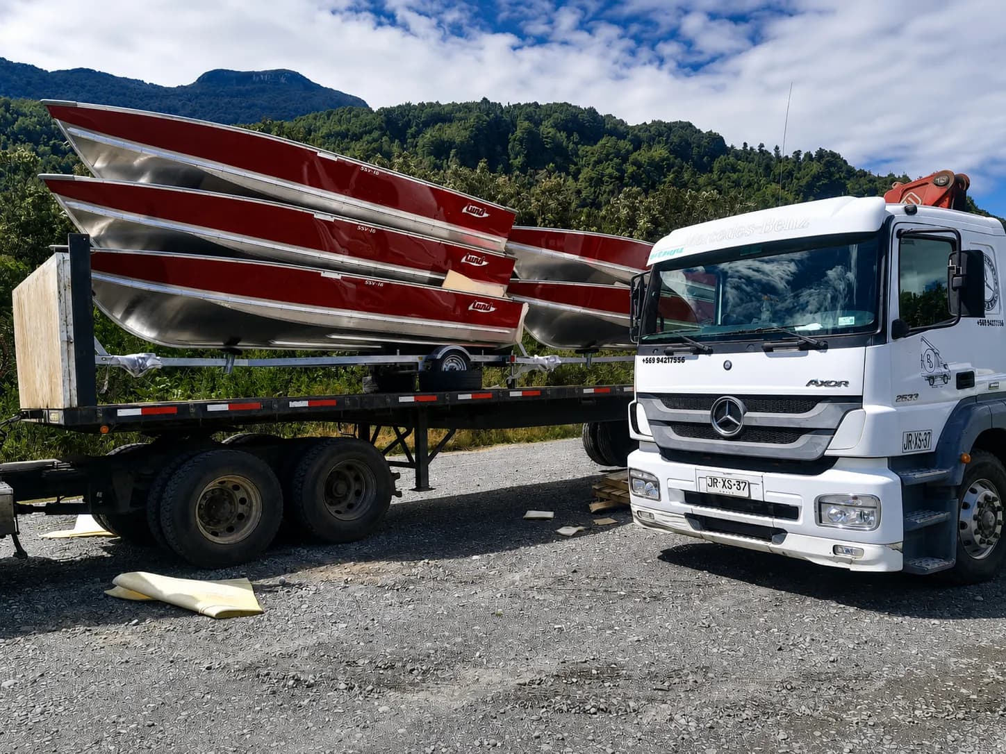 Camión plataforma cargado con embarcaciones de aluminio rumbo al sur